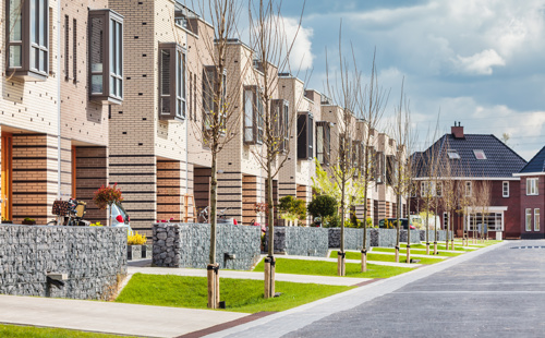 Op deze slide wordt getoond Row of contemporary family houses in the Dutch city of Zutphen By Martin Bergsma Adobestock 394665786.